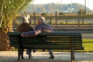 Dos personas mayores sentadas en un banco