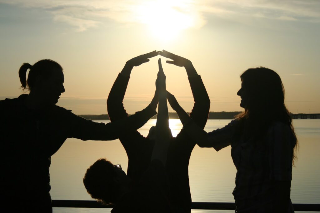 Siluetas de gente en atardecer haciendo Yoga