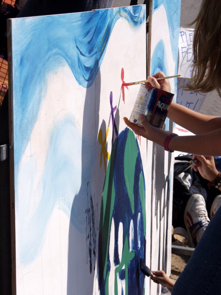 Manos pintando un mural