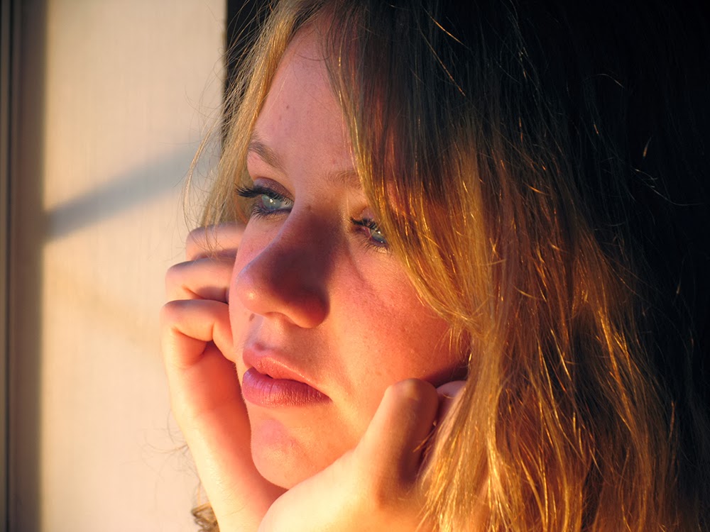 Chica triste mirando por la ventana