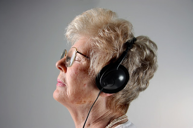 Mujer mayor escuchando música con auriculares