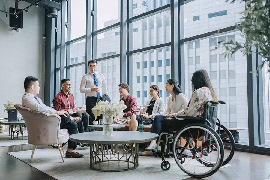 Reunión de personas, una de ellas en silla de ruedas