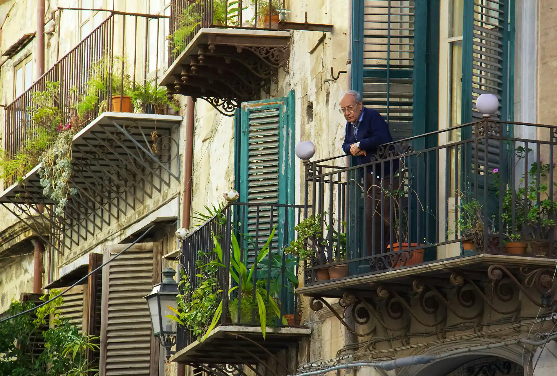 hombre mirando por el balcon de su casa
