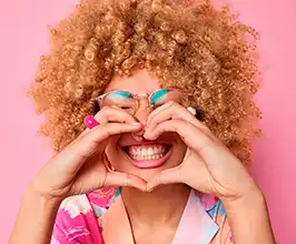 Dona fent un cor amb les mans sobre les dents